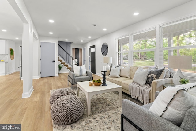 living room featuring light wood-style floors, recessed lighting, baseboards, and stairway
