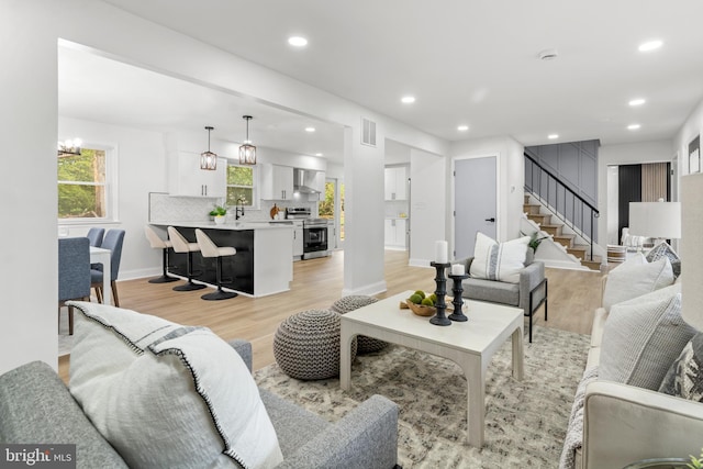 living room with stairs, recessed lighting, baseboards, light wood-type flooring, and visible vents