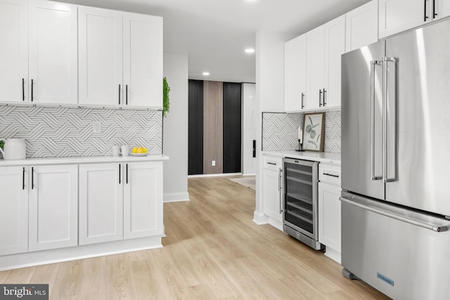 kitchen featuring white cabinetry, light countertops, beverage cooler, recessed lighting, and high end fridge