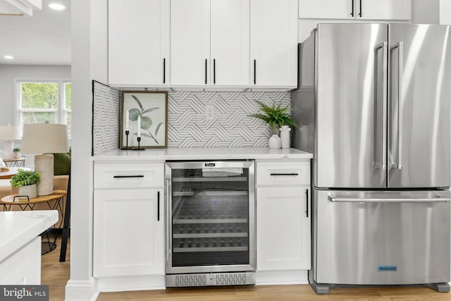bar with wine cooler, high quality fridge, recessed lighting, tasteful backsplash, and light wood finished floors