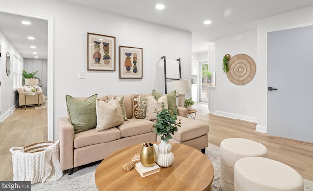 living area featuring recessed lighting, baseboards, and light wood finished floors