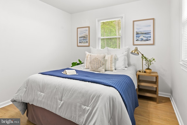 bedroom with baseboards and wood finished floors