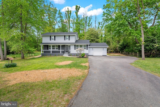 traditional home featuring a garage, a porch, driveway, and a front lawn