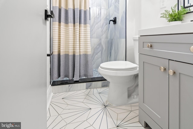 full bath with vanity, tile patterned floors, walk in shower, and toilet