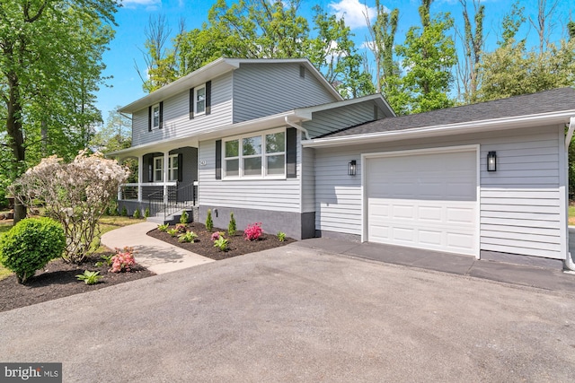 view of front of property with a garage, covered porch, and aphalt driveway
