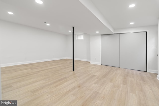 finished below grade area featuring recessed lighting, baseboards, and light wood-type flooring