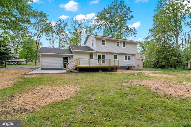 rear view of property featuring a lawn, a patio, and a wooden deck