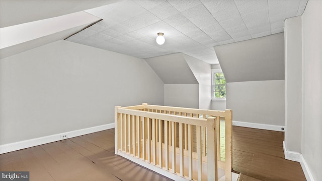 additional living space featuring baseboards, hardwood / wood-style floors, and lofted ceiling