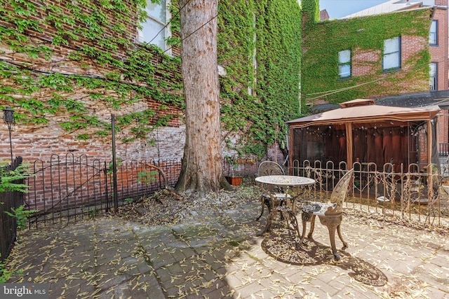 view of patio featuring fence and a gazebo