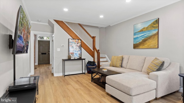 living area featuring recessed lighting, ornamental molding, stairs, and light wood-style flooring