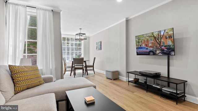 living room with baseboards, ornamental molding, and light wood-type flooring