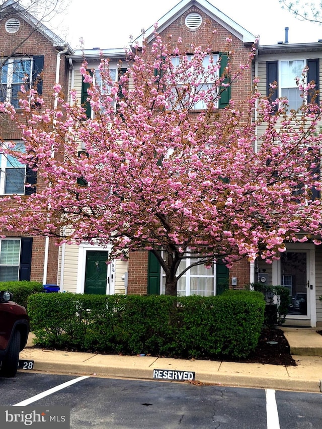 townhome / multi-family property featuring brick siding and uncovered parking