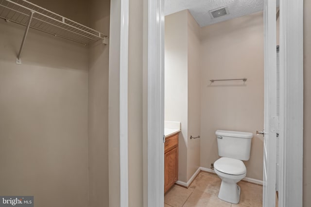 3707 Elmcrest Ln, Bowie, MD 20716 - bathroom featuring toilet, vanity, tile patterned flooring, baseboards, and a walk in closet