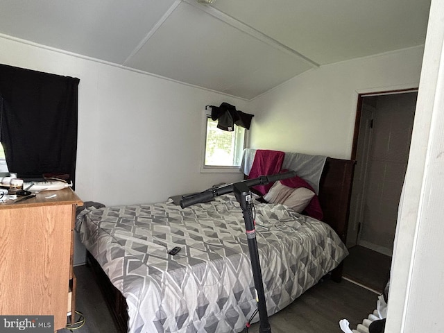 bedroom with wood finished floors and lofted ceiling