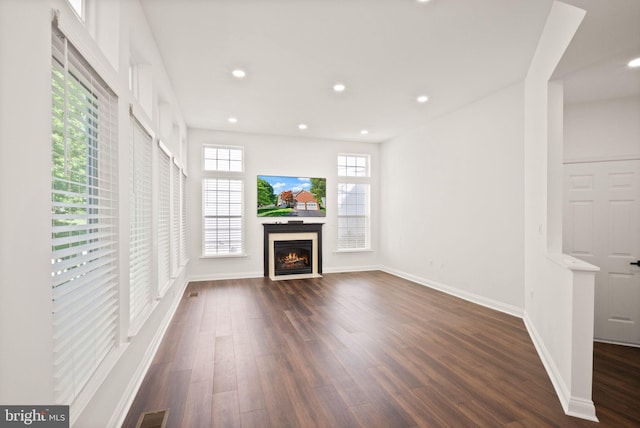 902 Santmyer Dr SE, Leesburg, VA 20175 - unfurnished living room with dark wood-type flooring, recessed lighting, baseboards, and a warm lit fireplace
