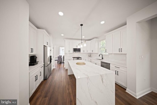 902 Santmyer Dr SE, Leesburg, VA 20175 - kitchen featuring appliances with stainless steel finishes, a sink, a kitchen island, decorative backsplash, and white cabinets