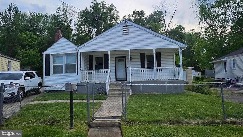 bungalow-style house featuring a gate, covered porch, a fenced front yard, and a front yard