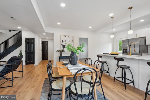dining area featuring stairway, light wood finished floors, recessed lighting, and visible vents