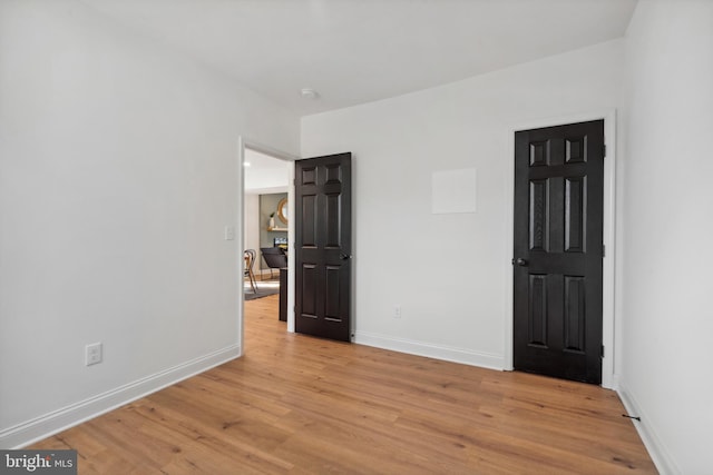 unfurnished bedroom featuring light wood-style floors and baseboards
