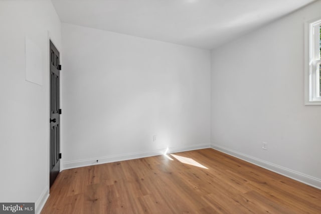 spare room with baseboards and light wood-style flooring