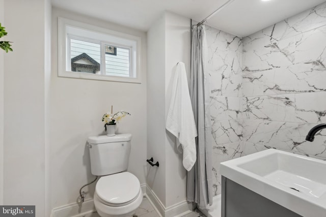 bathroom featuring a sink, baseboards, a shower with curtain, and toilet