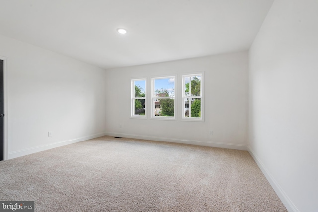 unfurnished room featuring baseboards, visible vents, recessed lighting, and light colored carpet