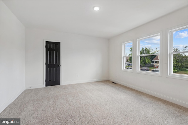 carpeted spare room with baseboards, recessed lighting, and a wealth of natural light