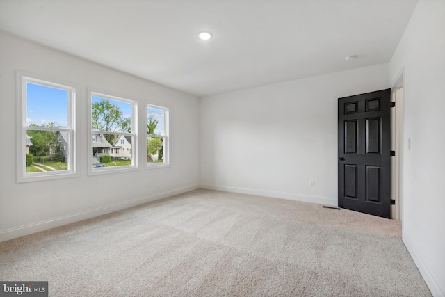 carpeted empty room with baseboards, recessed lighting, and visible vents