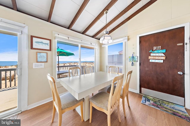 4505-4507 Ocean Blvd, Long Beach Township, NJ 08008 - dining area with baseboards, lofted ceiling with beams, a water view, and light wood-type flooring