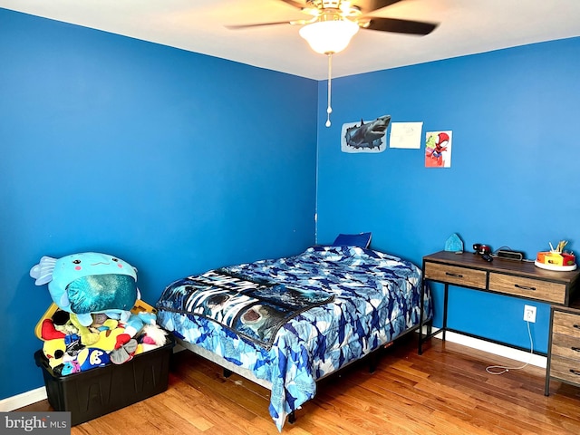 bedroom with wood finished floors, baseboards, and a ceiling fan