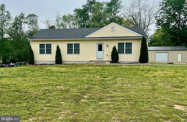 view of front of property featuring an outdoor structure, entry steps, and a front yard