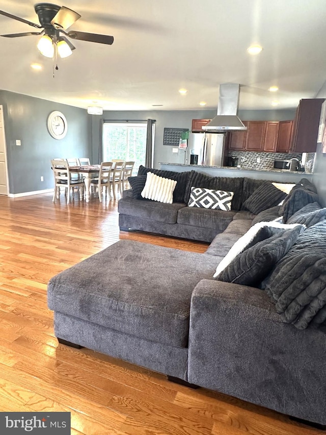 living area featuring light wood-style floors, ceiling fan, baseboards, and recessed lighting