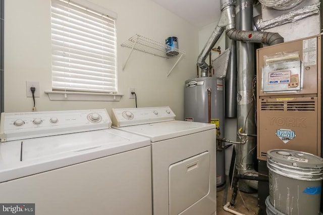 laundry area with laundry area, heating unit, washer and clothes dryer, and water heater