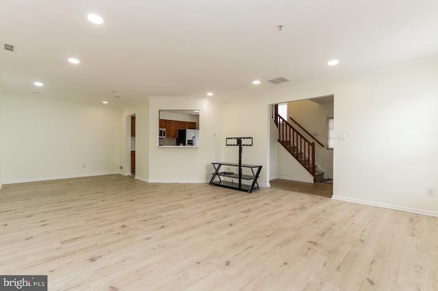 unfurnished living room with stairs, recessed lighting, visible vents, and light wood-style floors