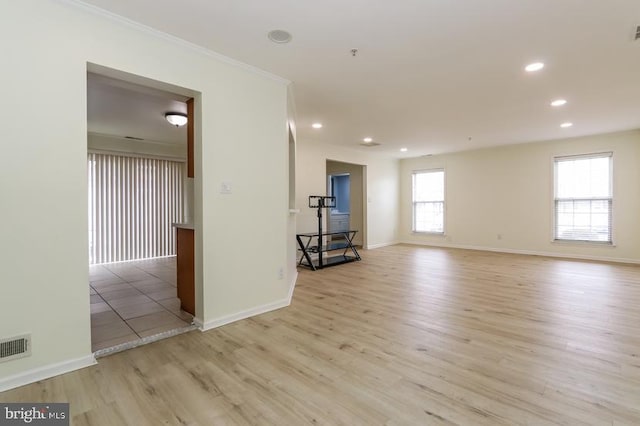 empty room with visible vents, crown molding, baseboards, light wood-style floors, and recessed lighting