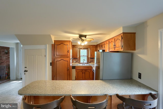 501 Walker Hill Rd, Newport, PA 17074 - kitchen with stainless steel appliances, a sink, brown cabinets, a breakfast bar, and ceiling fan