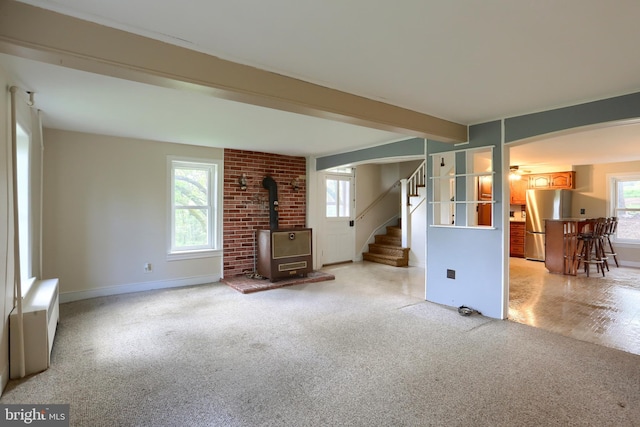 501 Walker Hill Rd, Newport, PA 17074 - unfurnished living room with a wood stove, light colored carpet, stairway, arched walkways, and baseboards