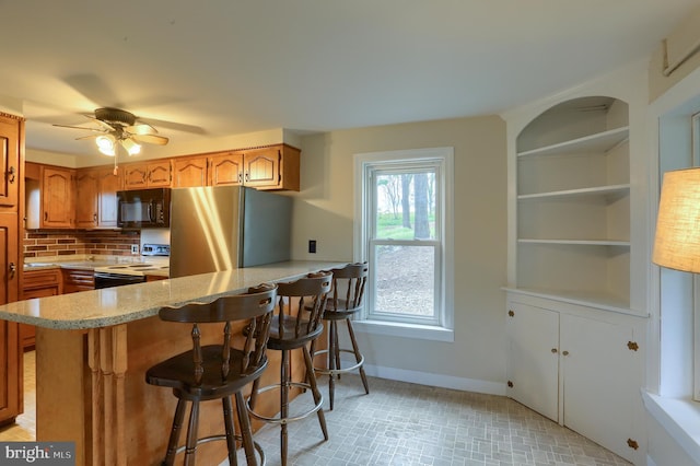 501 Walker Hill Rd, Newport, PA 17074 - kitchen with freestanding refrigerator, electric range oven, black microwave, baseboards, and a peninsula