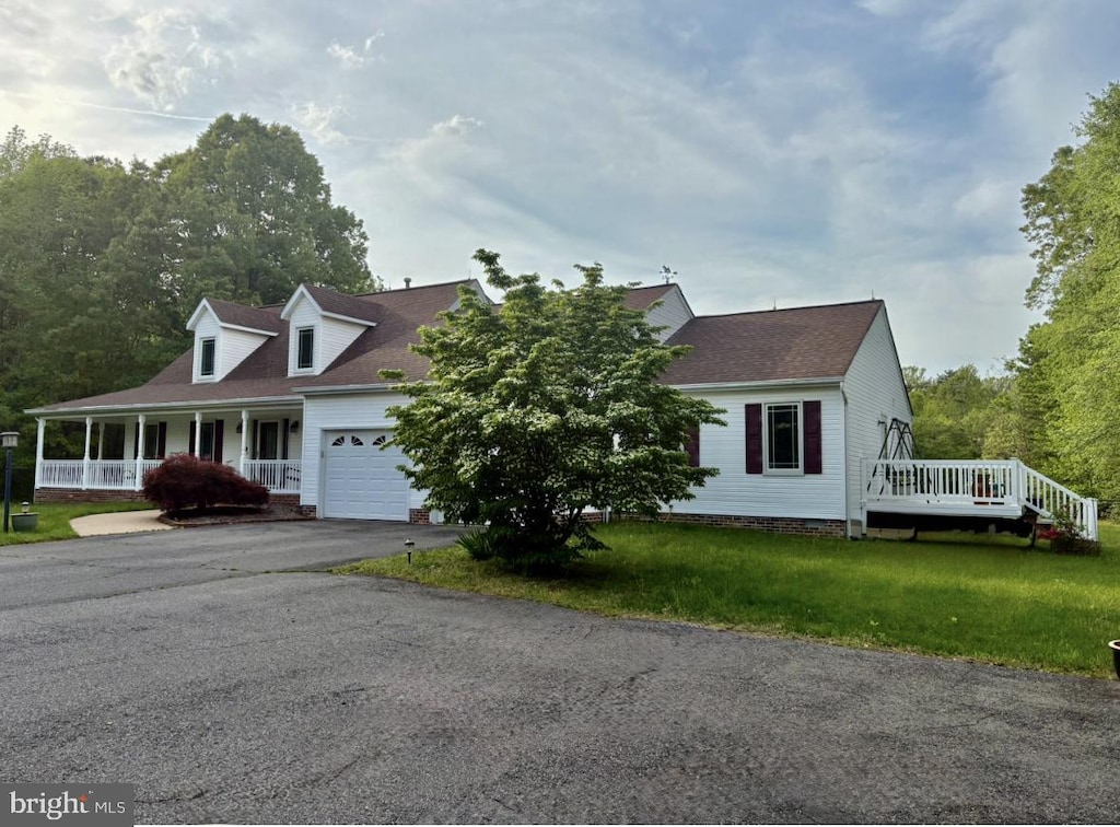 view of front of house featuring a porch, roof with shingles, aphalt driveway, an attached garage, and a front lawn