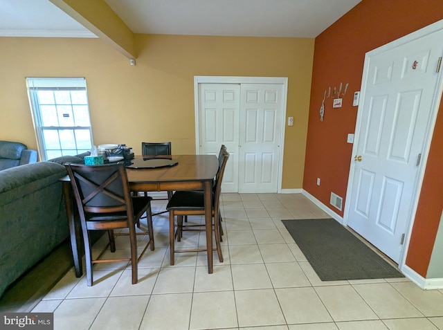 dining area with light tile patterned floors, baseboards, and ornamental molding