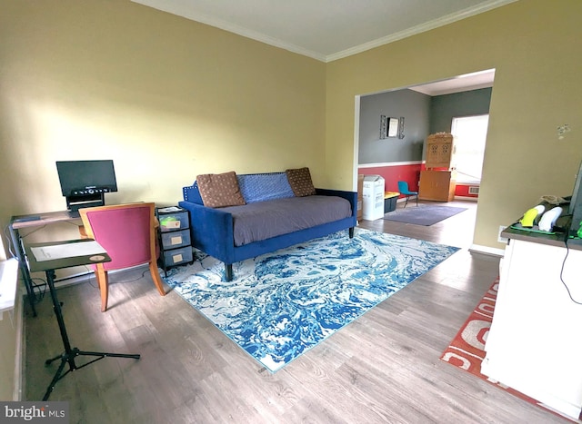 living area featuring wood finished floors, ornamental molding, and baseboards