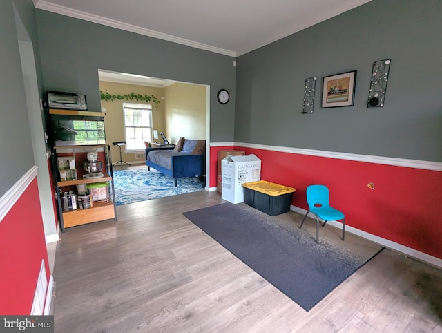 sitting room featuring wood finished floors, baseboards, and ornamental molding