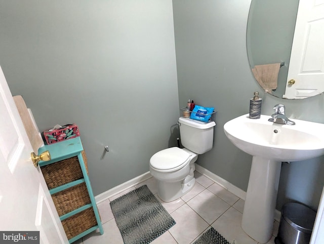 half bath with tile patterned floors, toilet, and baseboards