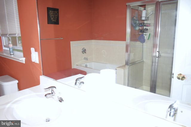 bathroom with a stall shower, a bath, and vanity