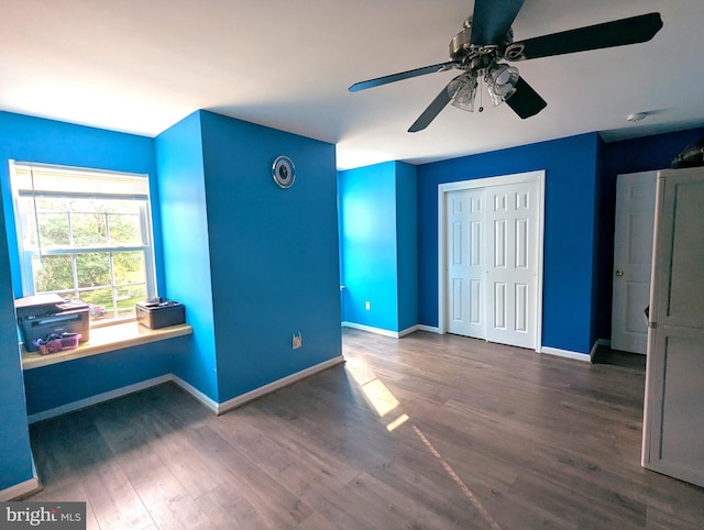 unfurnished bedroom with baseboards, wood finished floors, and a closet