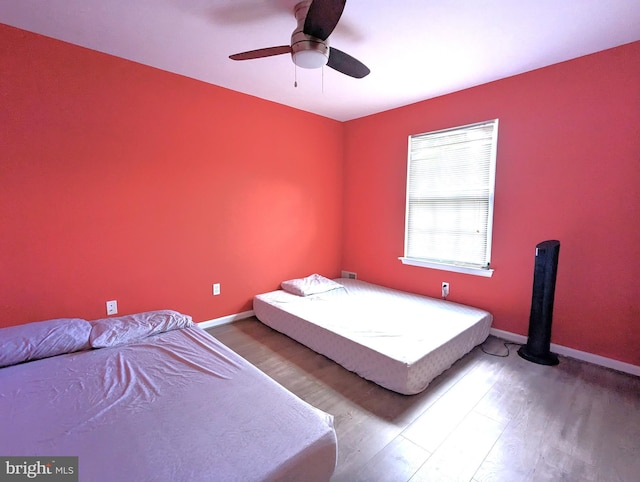 bedroom with wood finished floors, baseboards, and a ceiling fan