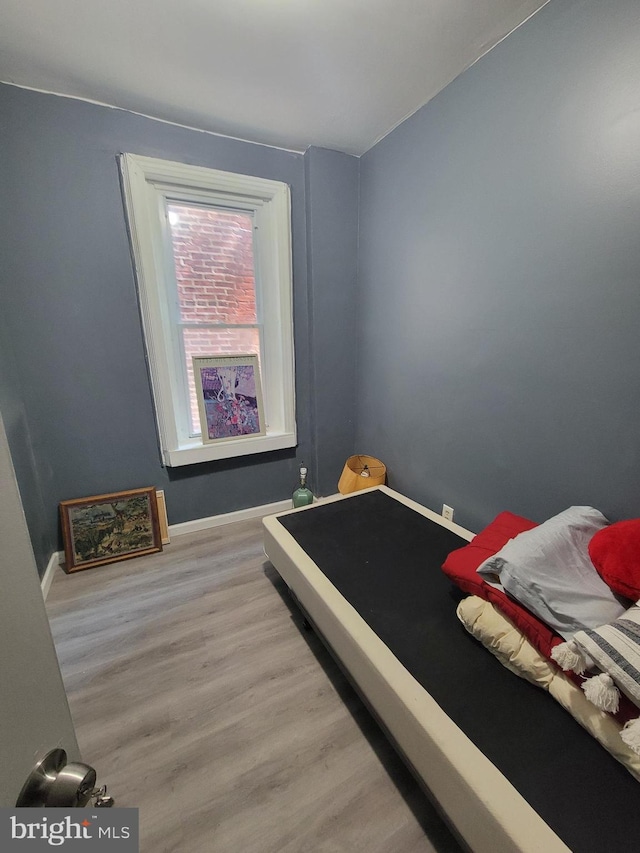 bedroom featuring baseboards and wood finished floors