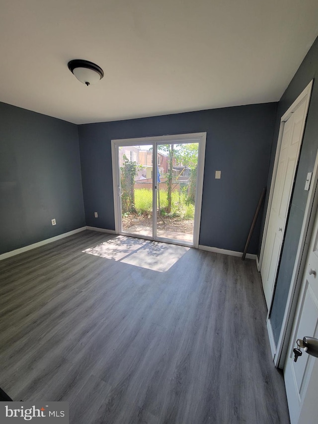 empty room featuring baseboards and wood finished floors