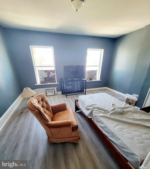 bedroom featuring baseboards and wood finished floors