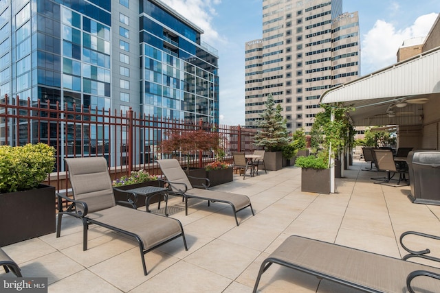 view of patio / terrace featuring ceiling fan and a city view